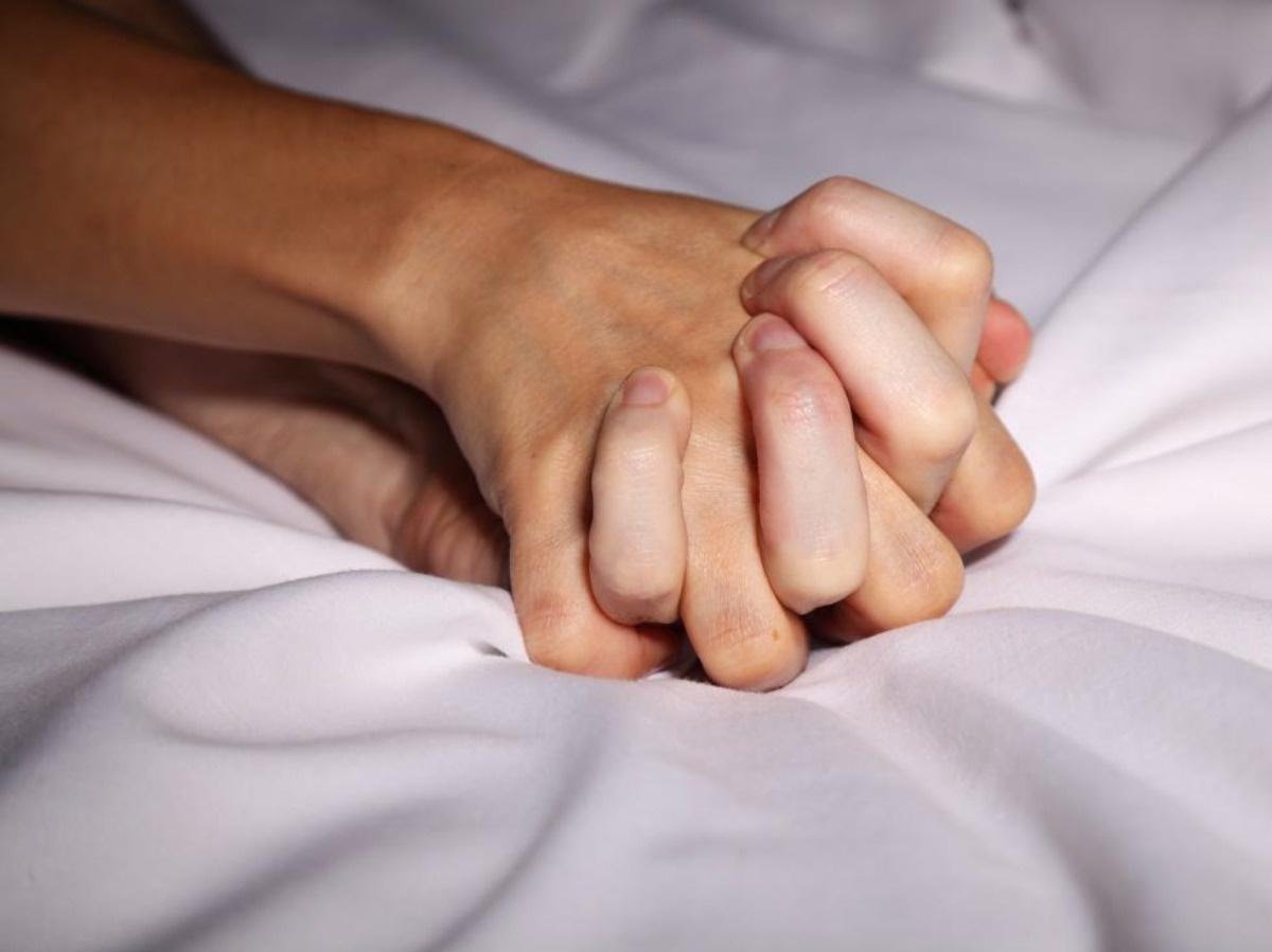 couple-holding-hands-in-bed-during-sex_6011088fa2026
